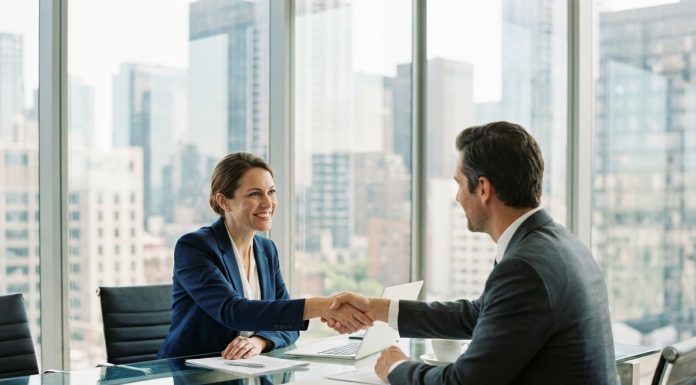 Femme d'affaires en costume navy serre la main d'un client dans un bureau moderne